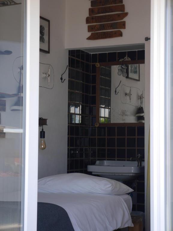 a bedroom with a bed and a tub and a mirror at Hostel & Surfcamp 55 in Ericeira