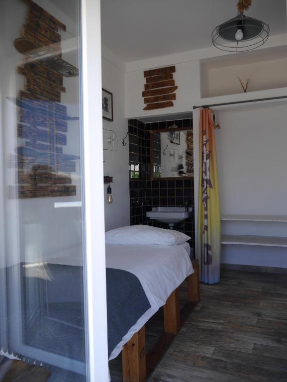 a small bedroom with a bed and a window at Hostel & Surfcamp 55 in Ericeira