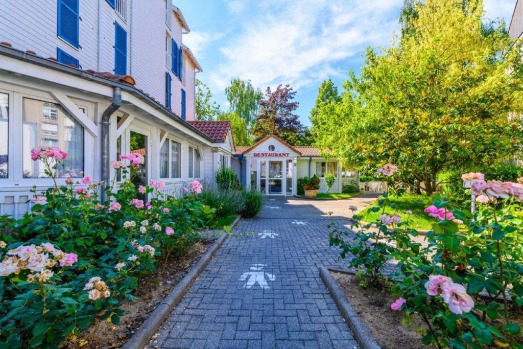 a cobblestone street in front of houses with flowers at Hotel Strasbourg - Montagne Verte & Restaurant Louisiane in Strasbourg