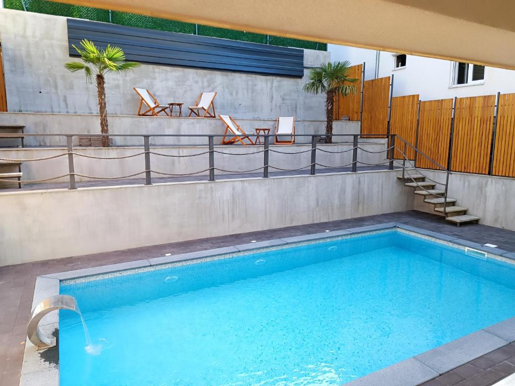 a large swimming pool with chairs at APARTMANI SUNNY SIDE in Vrnjačka Banja