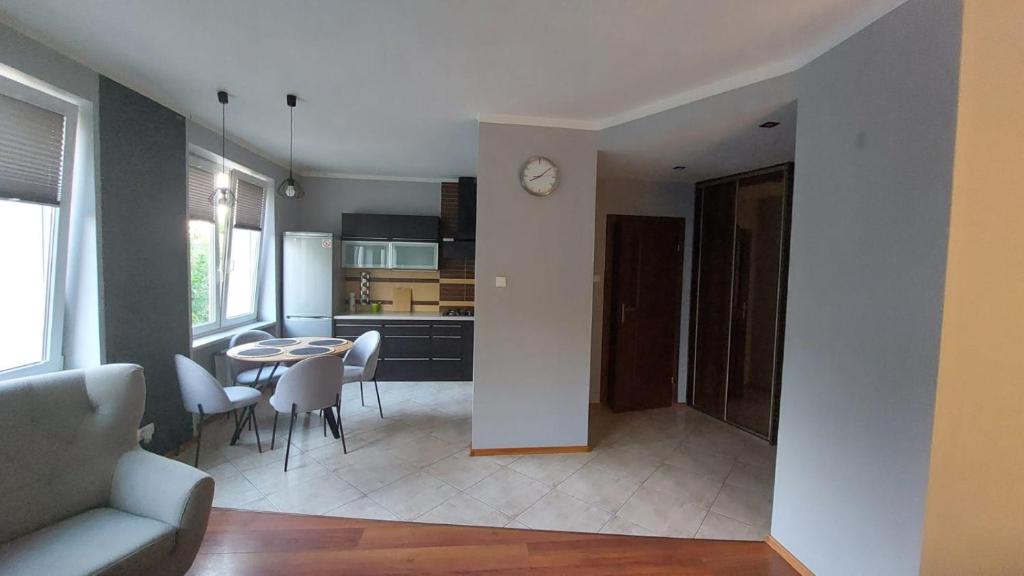 a kitchen and a living room with a table and chairs at Apartament CENTRUM in Giżycko