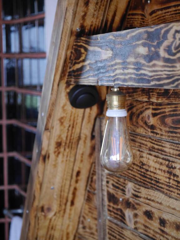 a light bulb hanging from the side of a wooden door at Hostel & Surfcamp 55 in Ericeira
