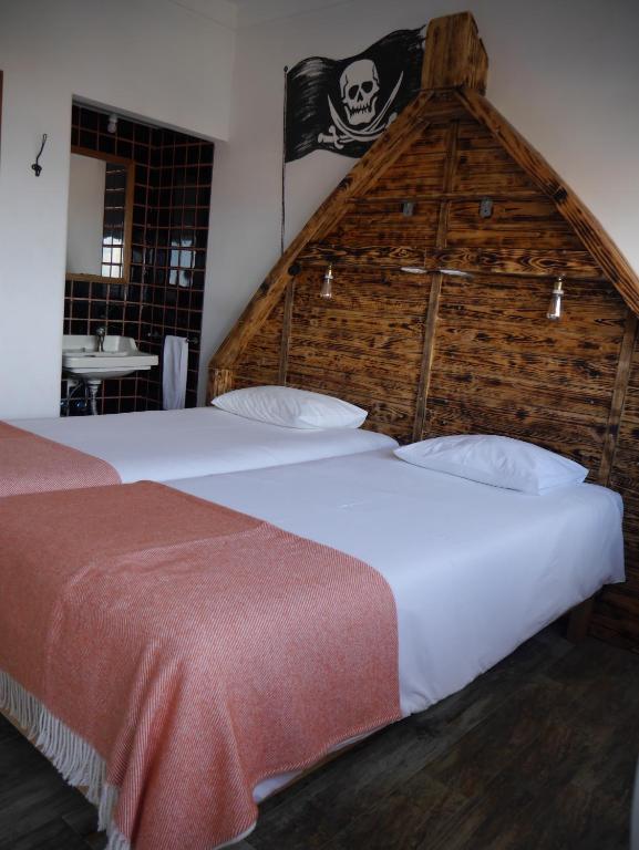 two beds in a room with a large wall at Hostel & Surfcamp 55 in Ericeira