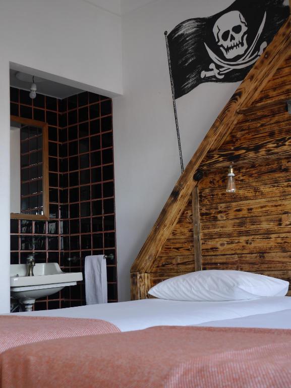 a bedroom with a skull sign on the wall at Hostel & Surfcamp 55 in Ericeira