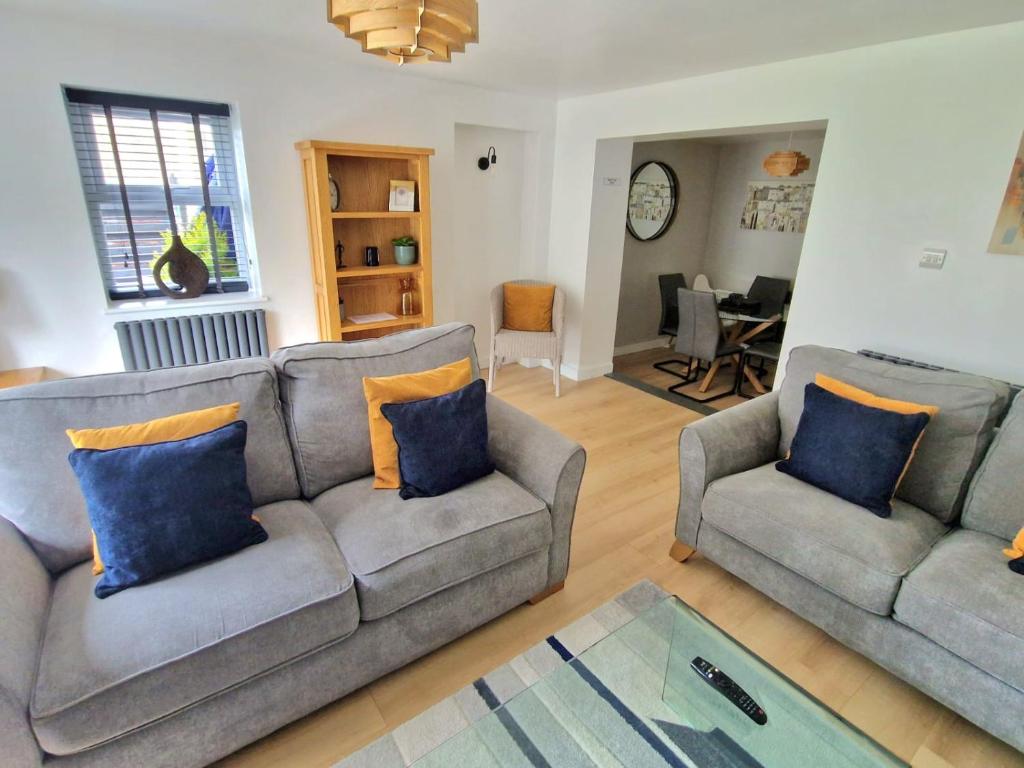 a living room with two couches and a table at 12 Ivy Cottage in St Ives