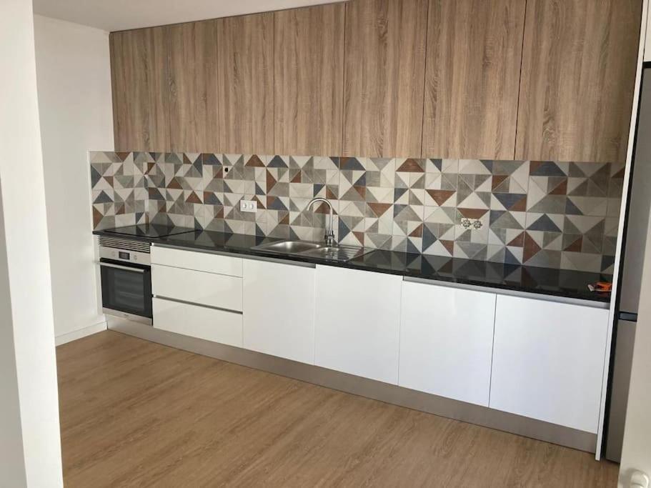 a kitchen with white cabinets and a counter top at Apartamento Renovado no Centro da Cidade - Casa4 in Coimbra