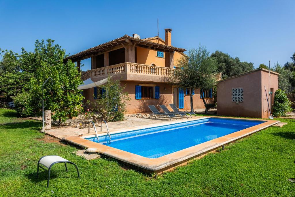 a villa with a swimming pool in front of a house at Sa Plana in Son Servera
