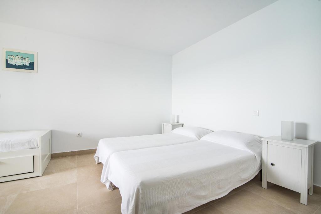 biała sypialnia z 2 łóżkami i 2 stolikami nocnymi w obiekcie Casa Daura Playa de Arinaga 2023 Reformed w mieście Arinaga