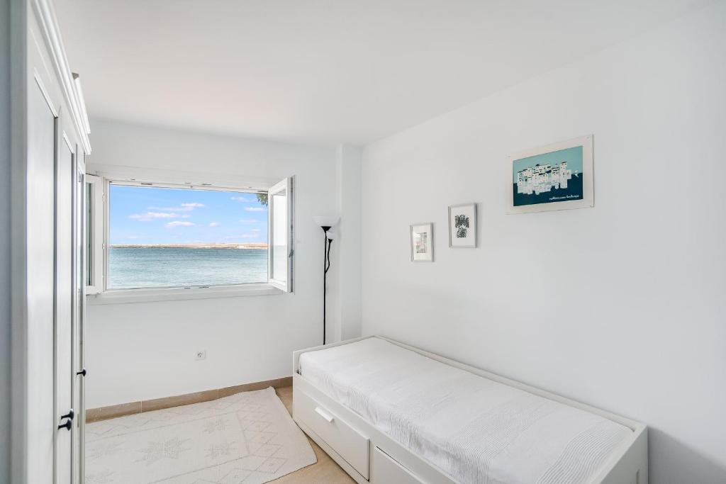 Camera bianca con letto e finestra di Casa Daura Playa de Arinaga 2023 Reformed a Arinaga
