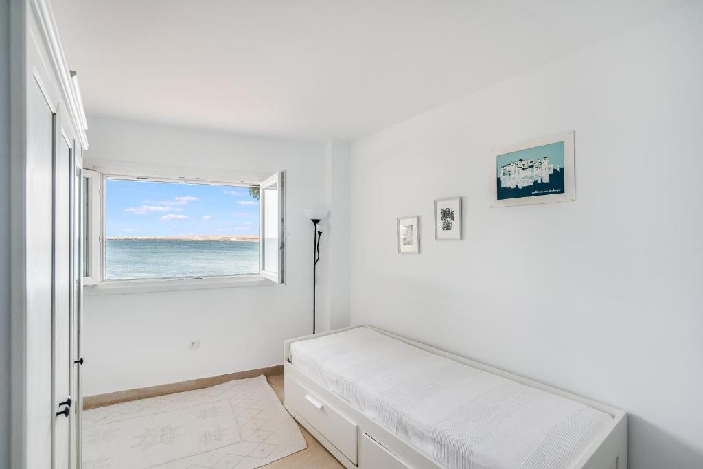 biały pokój z łóżkiem i oknem w obiekcie Casa Daura Playa de Arinaga 2023 Reformed w mieście Arinaga