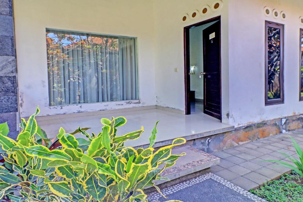 una puerta delantera de una casa con una planta en OYO 92706 Nadia Pansion, en Ketewel