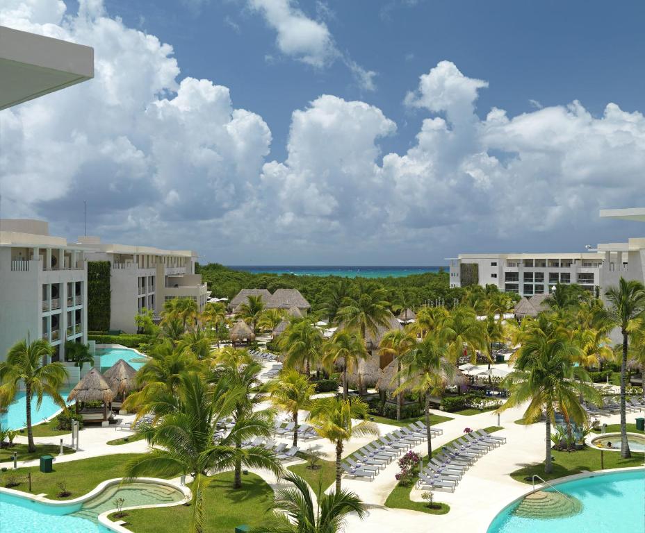 
a beach with palm trees and palm trees at Paradisus Playa del Carmen All Inclusive in Playa del Carmen
