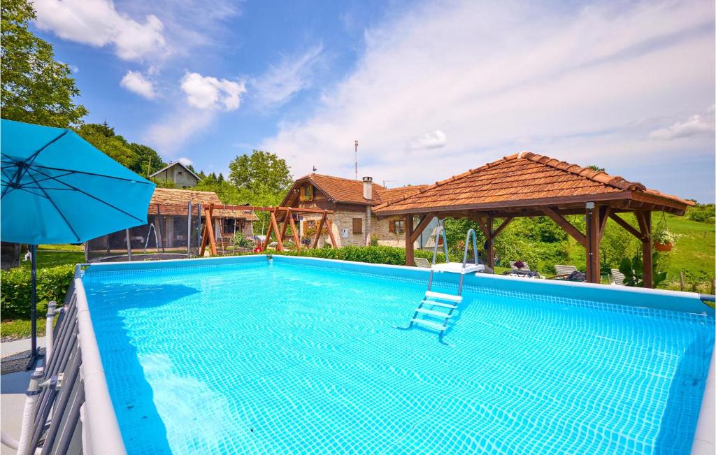 - une piscine avec une chaise et un parasol dans l'établissement 2 Bedroom Cozy Home In Hrastovica, 
