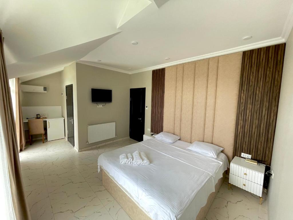 1 dormitorio con 1 cama blanca y TV en Four Seasons Hotel, en Batumi