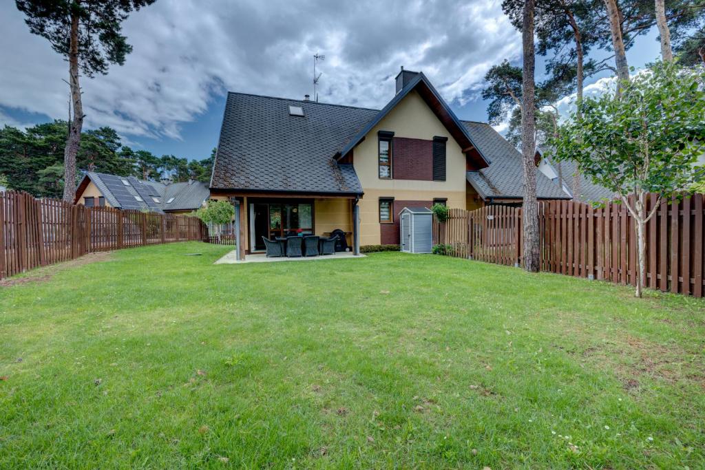 a house with a fence and a yard at Willa Międzywodzie in Międzywodzie