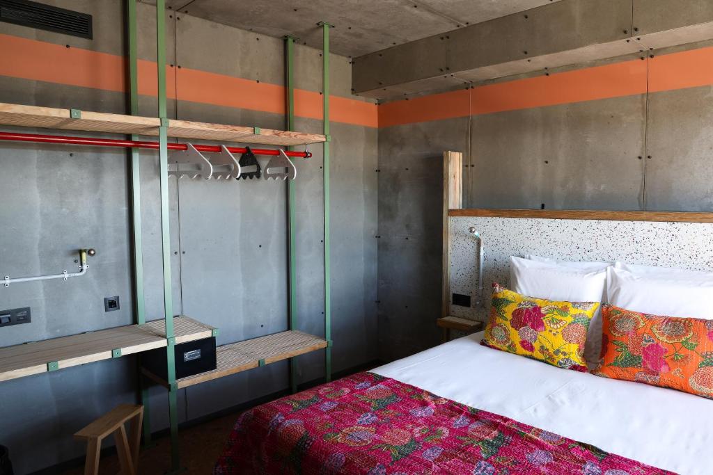 An industrial-style bedroom with a double bed and an elevated bunk sleeping area.
