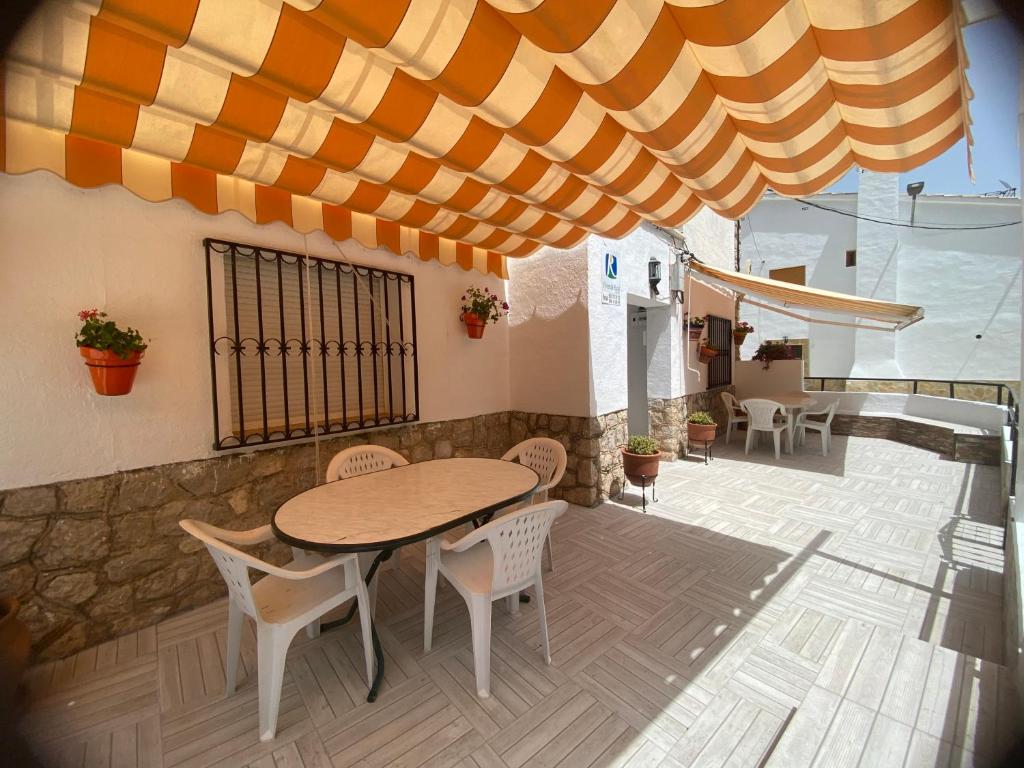 - une table et des chaises sous un parasol sur la terrasse dans l'établissement ApartamentoS Rosa, à Arroyo Frío
