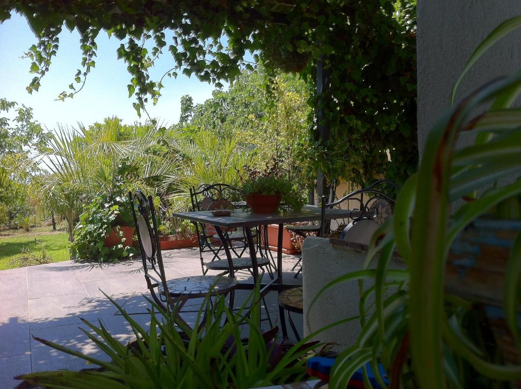 una mesa y sillas en un patio con plantas en Mamma Etna, en Pedara