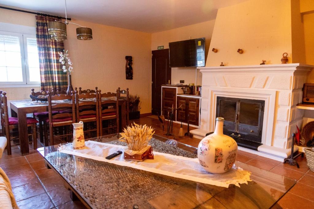 a living room with a fireplace and a dining room at Casa Rural La Carbonera in Cuenca
