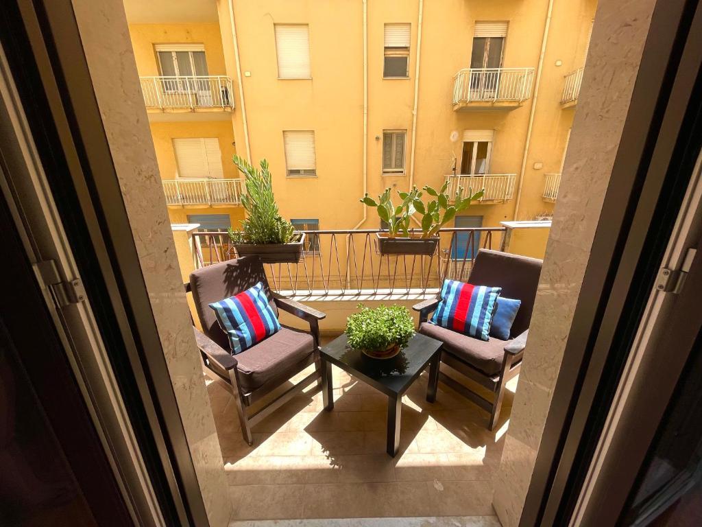 a balcony with two chairs and a table and a building at Golden House - Trilocale nel Cuore di Agrigento in Agrigento