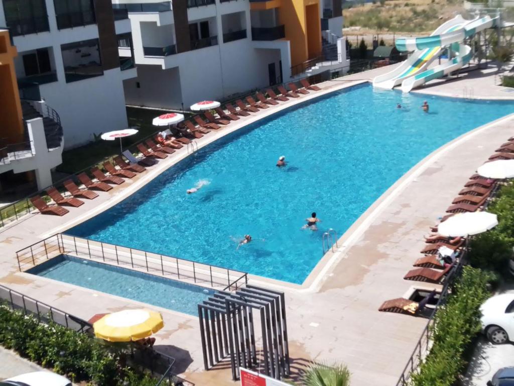 a large swimming pool with people swimming in it at Mersin condominium Life City with pool and sea in Erdemli