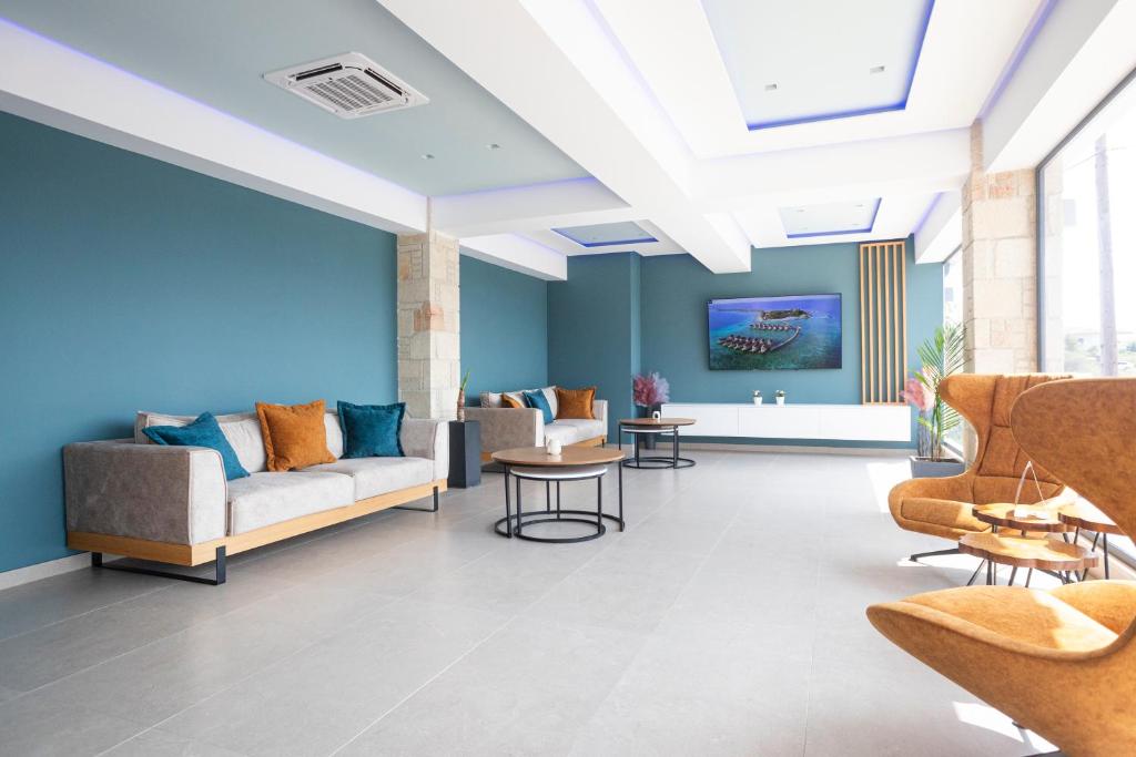 a lobby with blue walls and couches and tables at Kallithea Village hotel in Kallithea Halkidikis