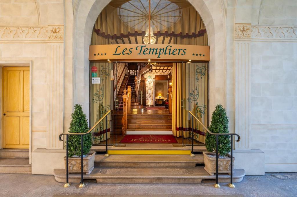 einen Eingang zu einem Gebäude mit einer Treppe und einem Schild in der Unterkunft Grand Hôtel Des Templiers in Reims