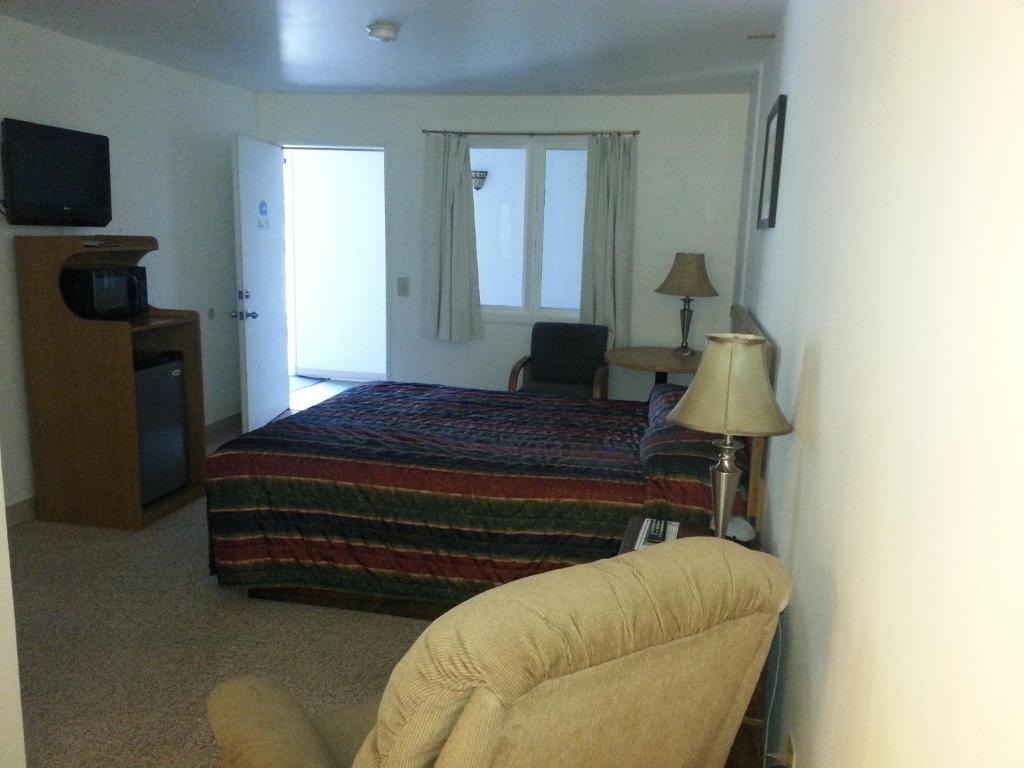 a hotel room with a bed and a chair at Autumn's Inn in Roundup