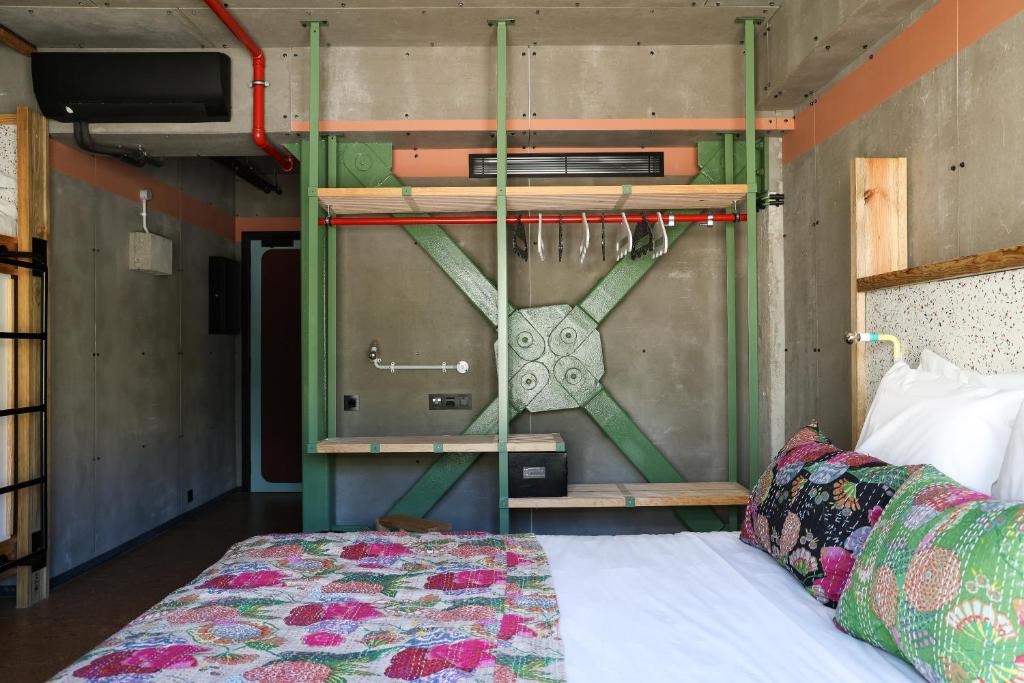 A colorful bed opposite an industrial open wardrobe and hanging rail.