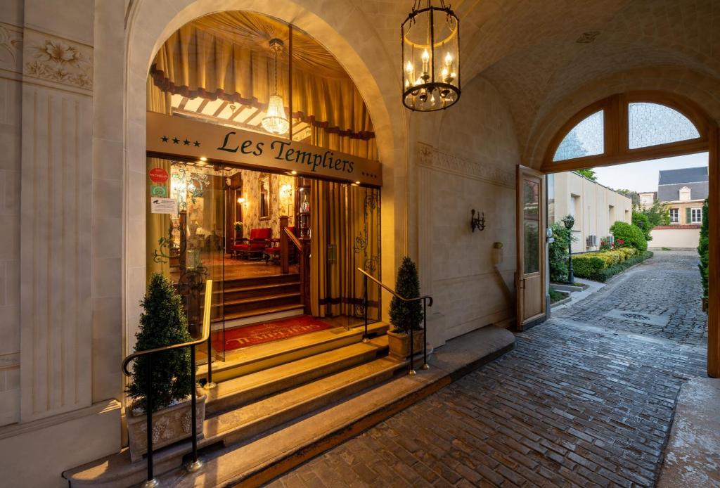 a store front with stairs and a chandelier at Grand Hôtel Des Templiers in Reims