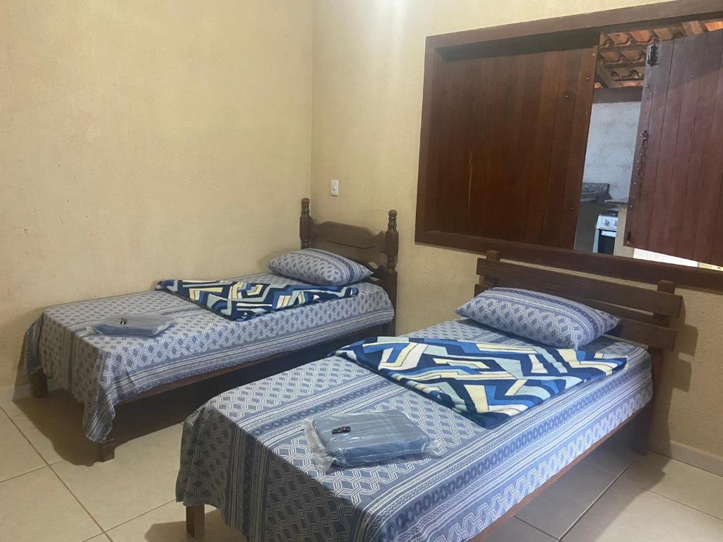 Habitación con 2 camas y sábanas azules y blancas. en Pousada Chales da Canastra, en Vargem Bonita