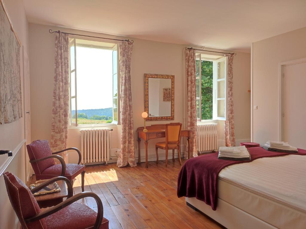 - une chambre avec un lit, une table et des chaises dans l'établissement Château du Pommoy, à Roussillon-en-Morvan