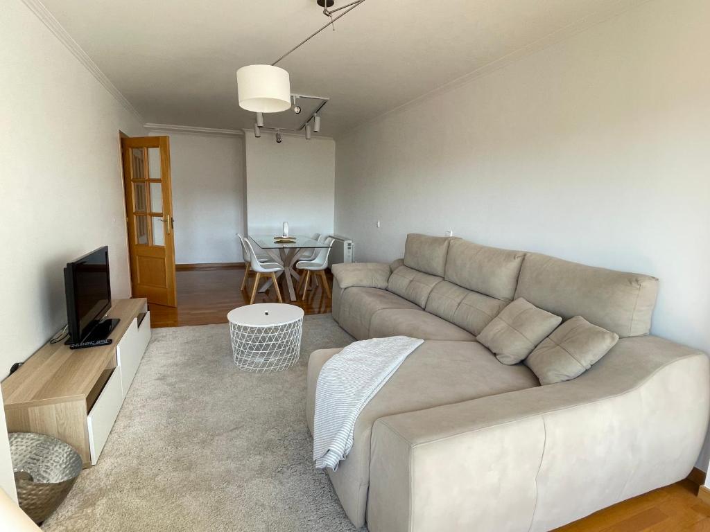 ein Wohnzimmer mit einem Sofa und einem Tisch in der Unterkunft Piso Sirius in Vilagarcia de Arousa