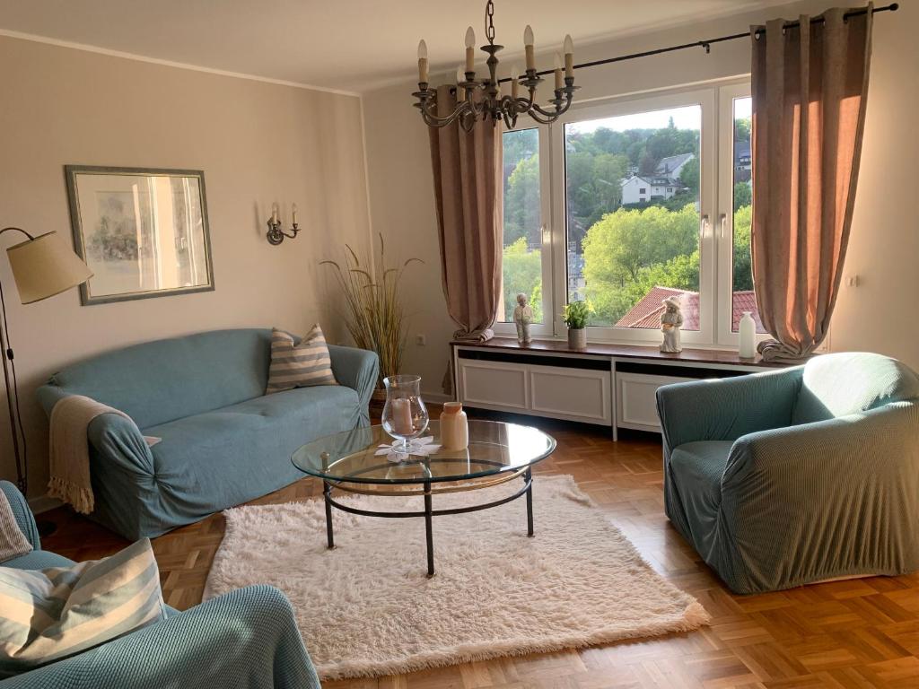 uma sala de estar com um sofá azul e uma mesa de vidro em Stadtperle Sundern em Sundern