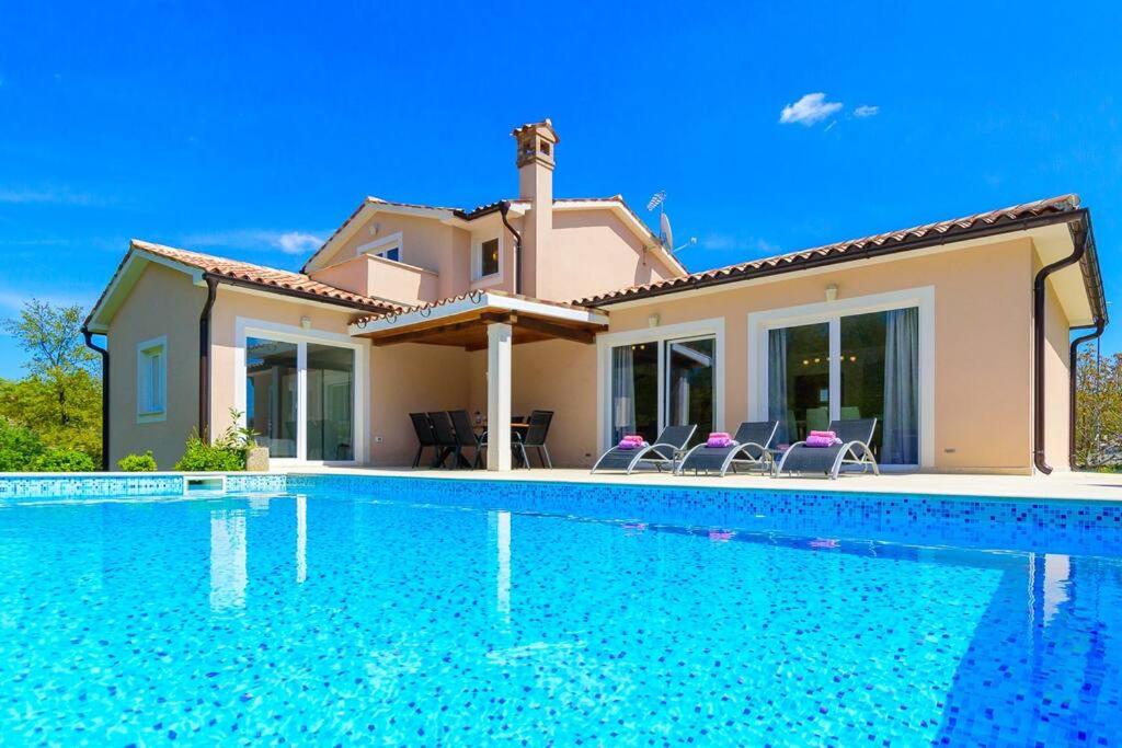 a villa with a swimming pool in front of a house at Villa Emili by IstriaLux in Svetvinčenat