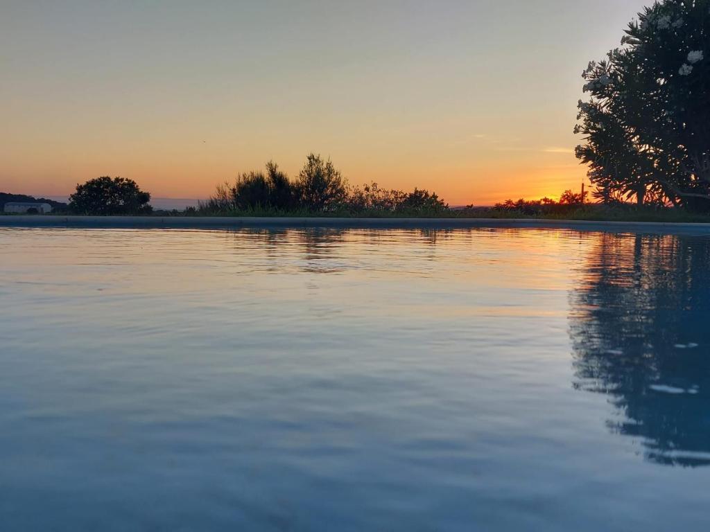 einen Sonnenuntergang über einem großen Wasserkörper in der Unterkunft Herdade do Gizo - Casa dos Sobreiros in Cuba