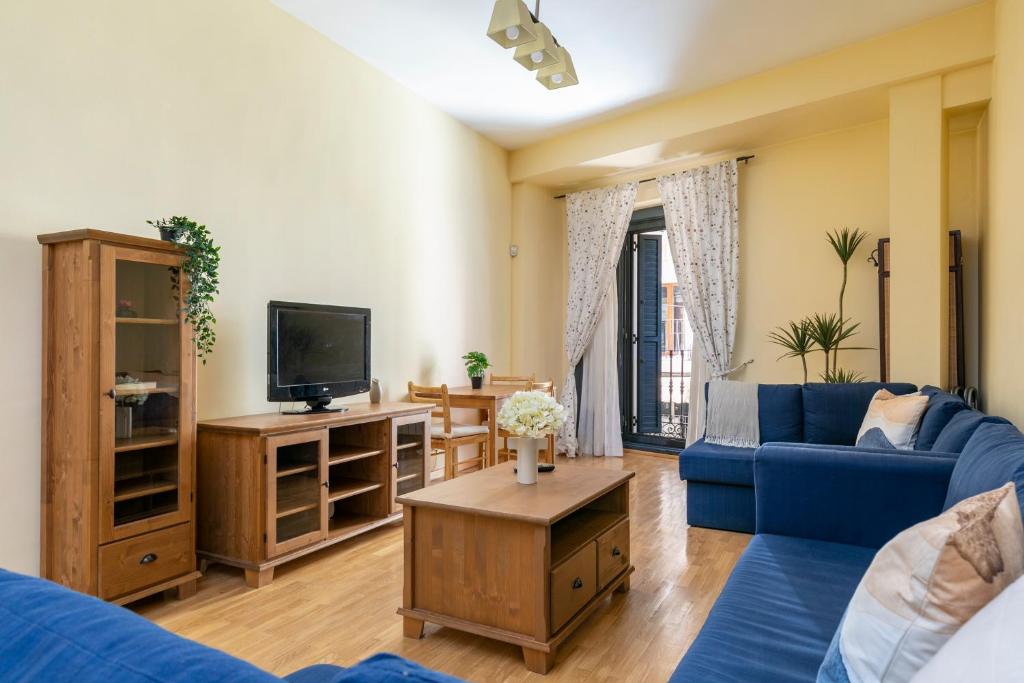 Charming Plaza Mayor II في مدريد: غرفة معيشة مع أريكة زرقاء وتلفزيون