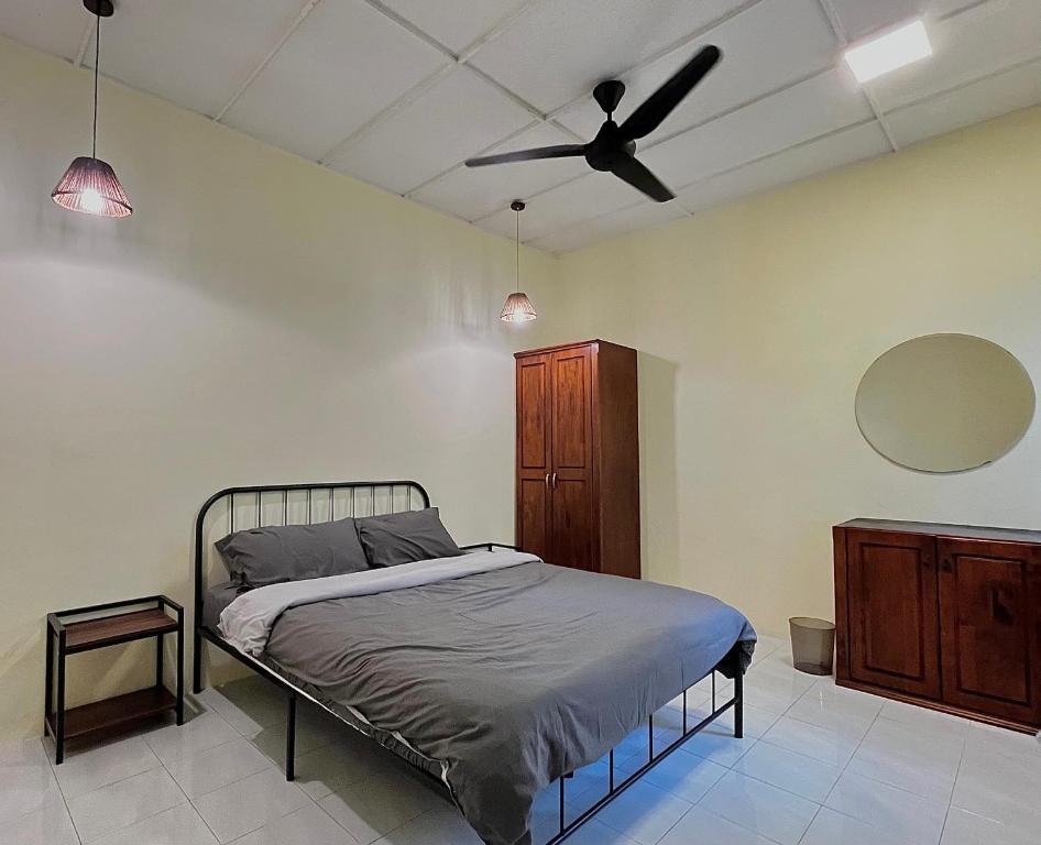 a bedroom with a bed and a ceiling fan at V Lodge in Kuantan
