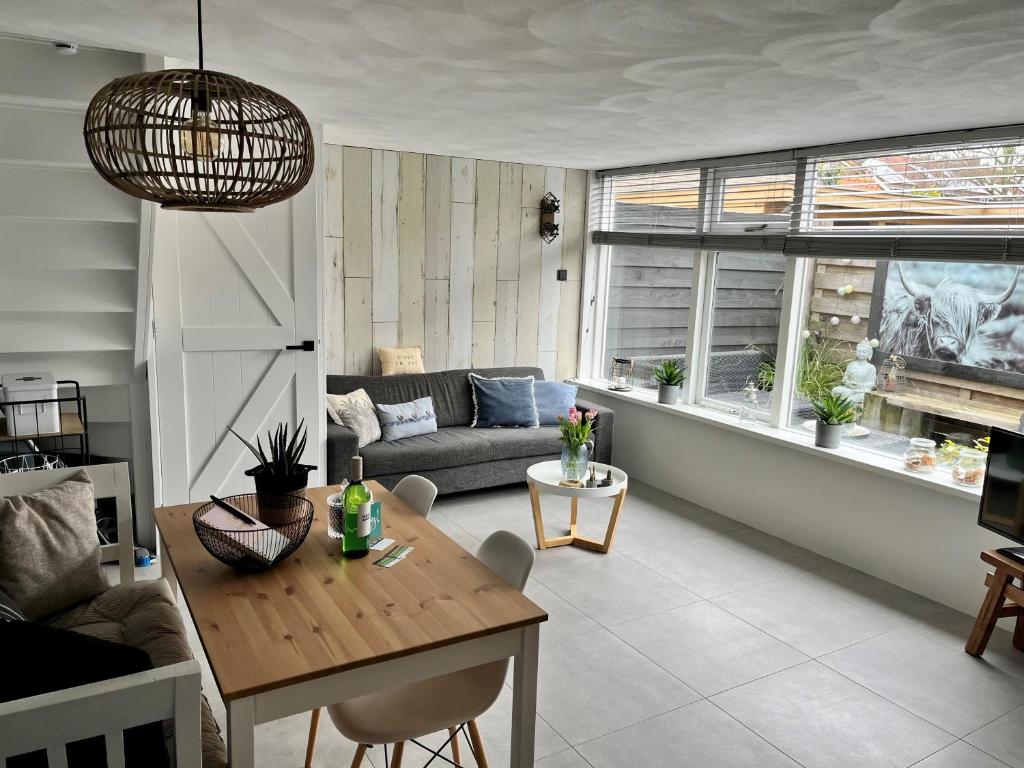 ein Wohnzimmer mit einem Tisch und einem Sofa in der Unterkunft HuisjehurenEgmond in Egmond aan Zee
