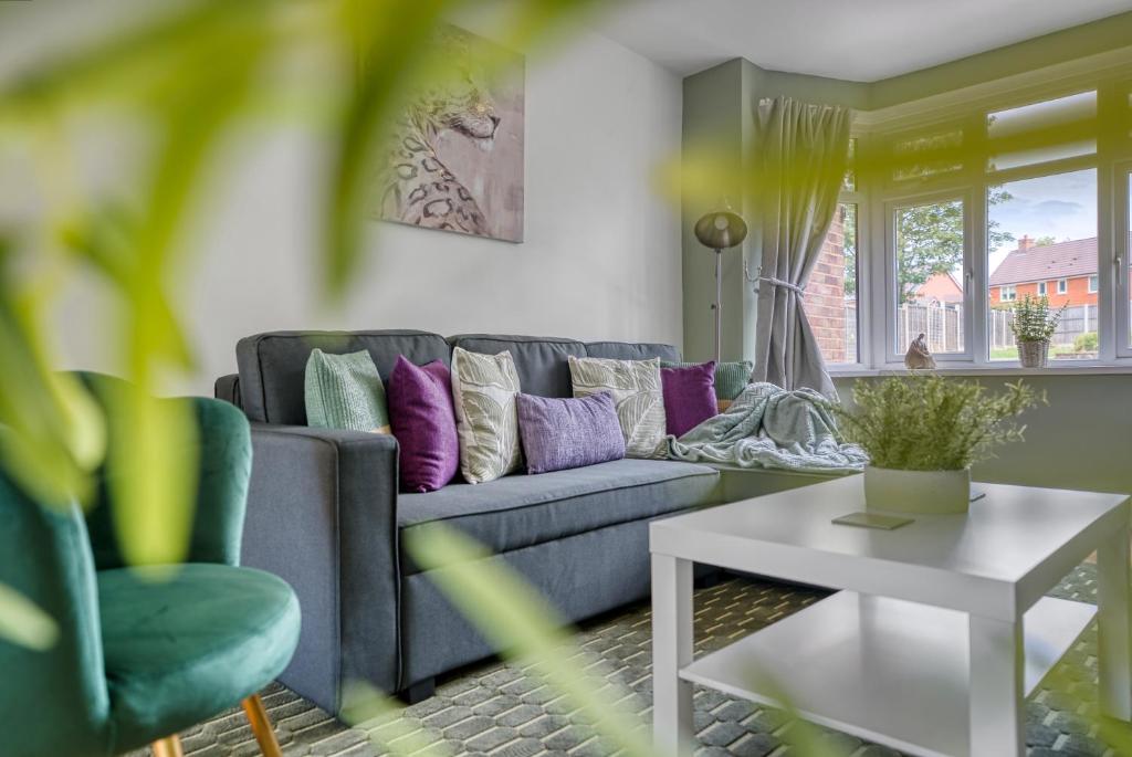 a living room with a blue couch and purple pillows at Team Accomodation 4 Bedroom Free Parking WiFi Moseley Birmingham near City Centre NEC BHX in Birmingham