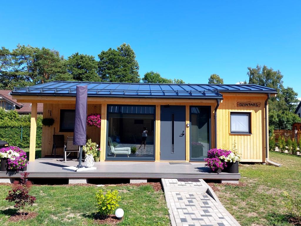 艾納日的住宿－Jūras dzintars，一座黄色的小房子,设有太阳能屋顶