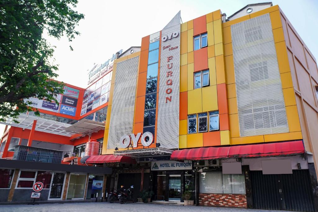 a building with a colorful facade on a street at Capital O 142 Hotel Al Furqon Syariah in Palembang