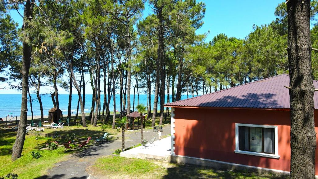 - un petit bâtiment rouge avec vue sur l'océan dans l'établissement Oxygen Hotel, à Shekvetili