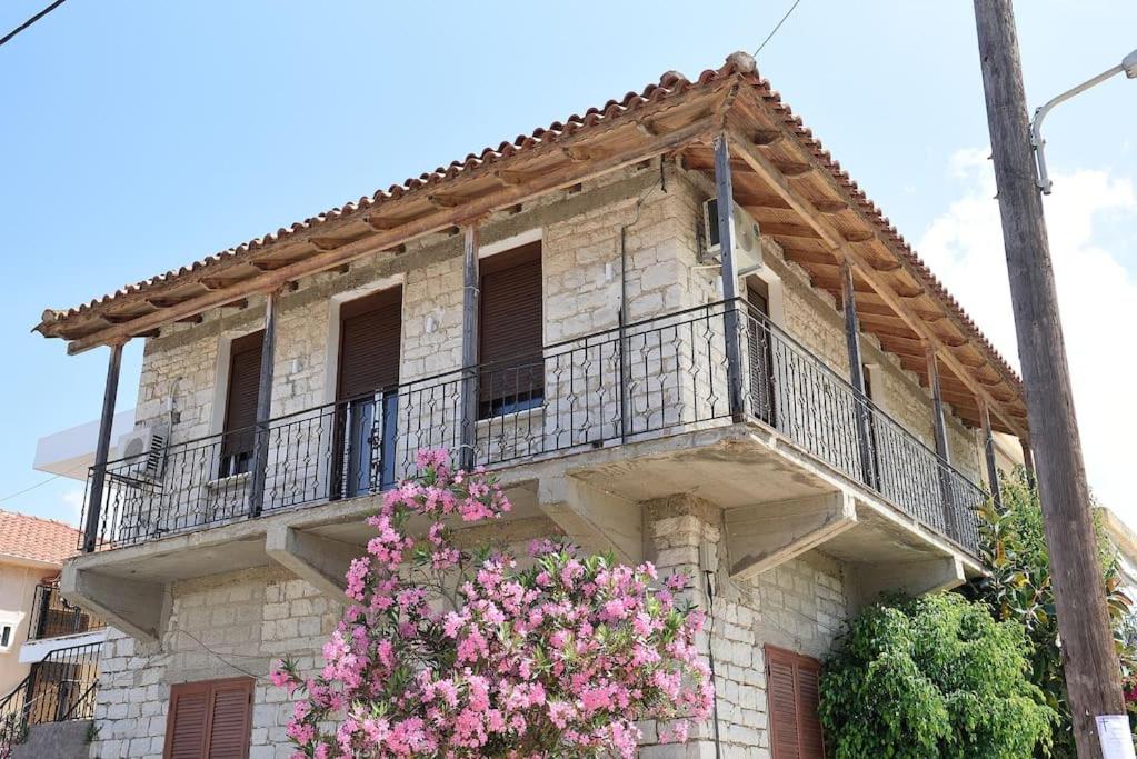 un antico edificio con balcone con fiori rosa di Sophia's stone apartment 