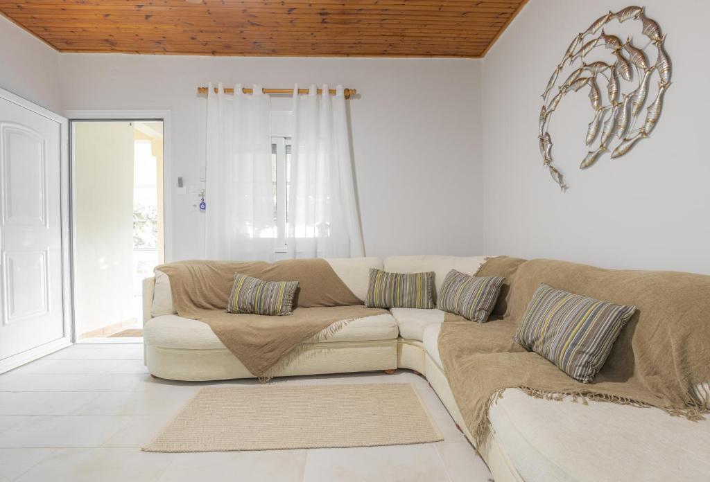 un soggiorno bianco con divano e finestra di KOUROUTA BEACH HOUSE a Kourouta