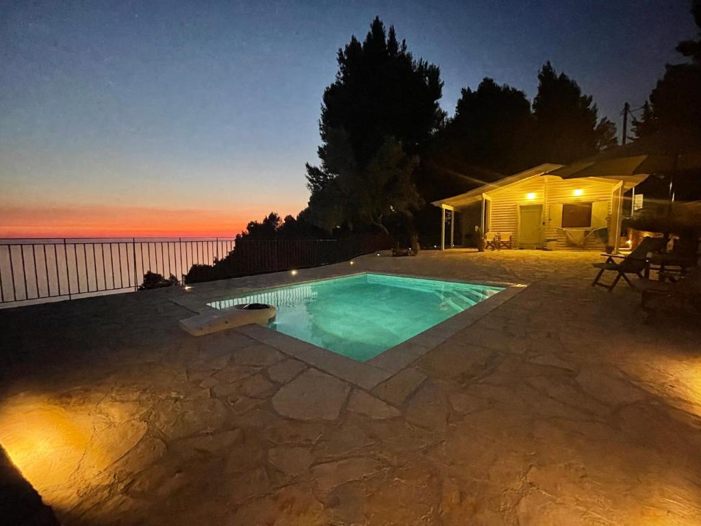 a swimming pool in a backyard at night at The White House above Egremni in Athani