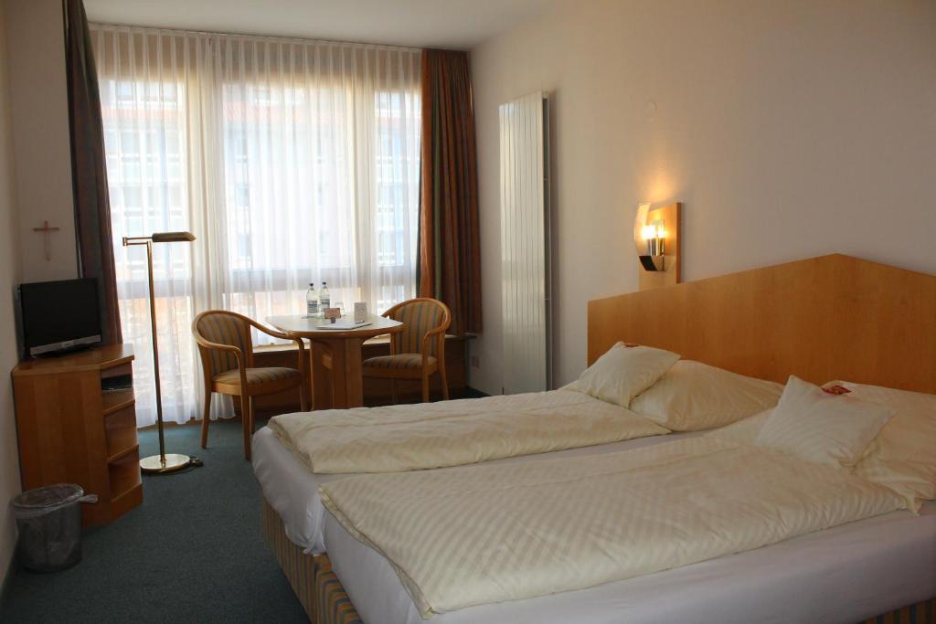 a hotel room with a bed and a table at Evangelische Diakonissenanstalt Stuttgart in Stuttgart