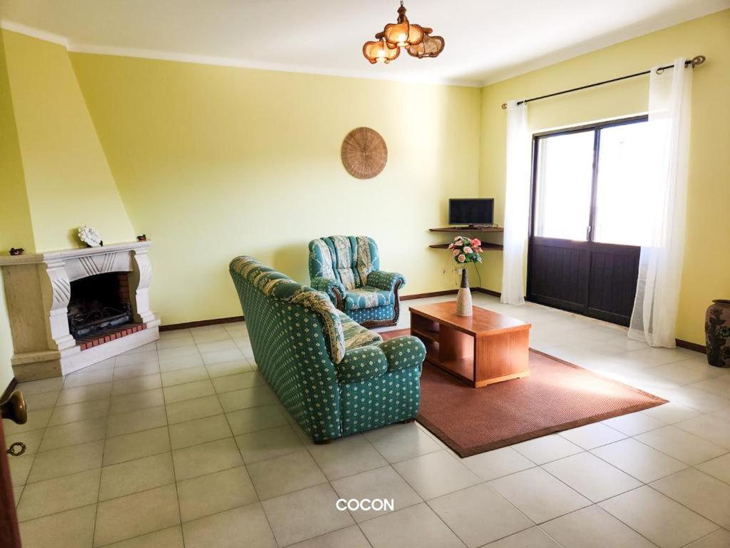 ein Wohnzimmer mit 2 Stühlen und einem Kamin in der Unterkunft Casa Aveiro 