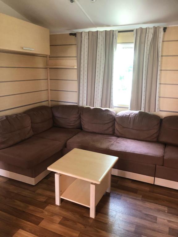 a living room with a couch and a coffee table at Mobil home in Damiatte