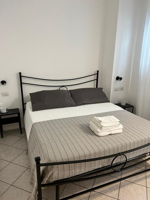 Una cama en un dormitorio con dos toallas. en JACAM home free parking, en Albese Con Cassano